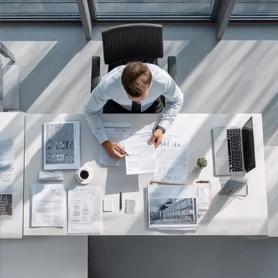 نمای بالا از میز کار کارشناس تحریریه تجارت دانه در حال بررسی اسناد، داده‌های تحلیلی و گزارش‌های تخصصی حوزه تأمین نهاده‌های دامی